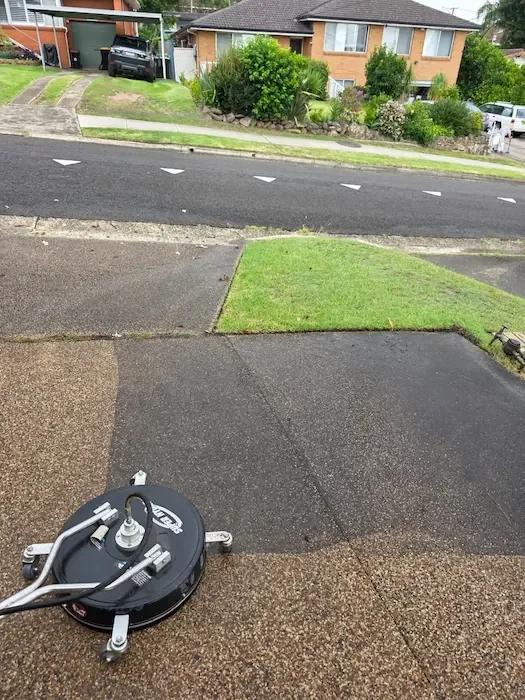 Surface cleaner on aggregate driveway showing clean versus dirty sections