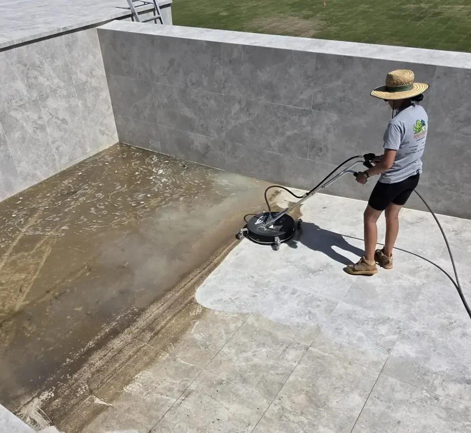 Professional surface cleaner on outdoor tiles showing dirty versus cleaned sections